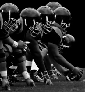 Front line of football players holding football