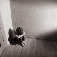 Child sitting in the corner of a room