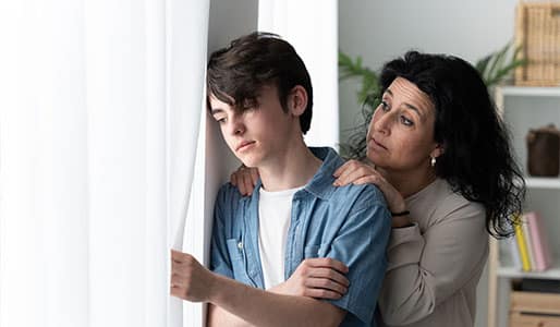 teen boy and concerned mom at window