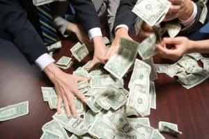 hands grabbing money pile