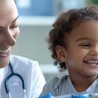 Doctors joyfully giving a cheerful child a vaccine.