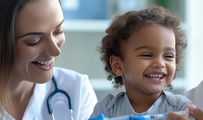 Doctors joyfully giving a cheerful child a vaccine.